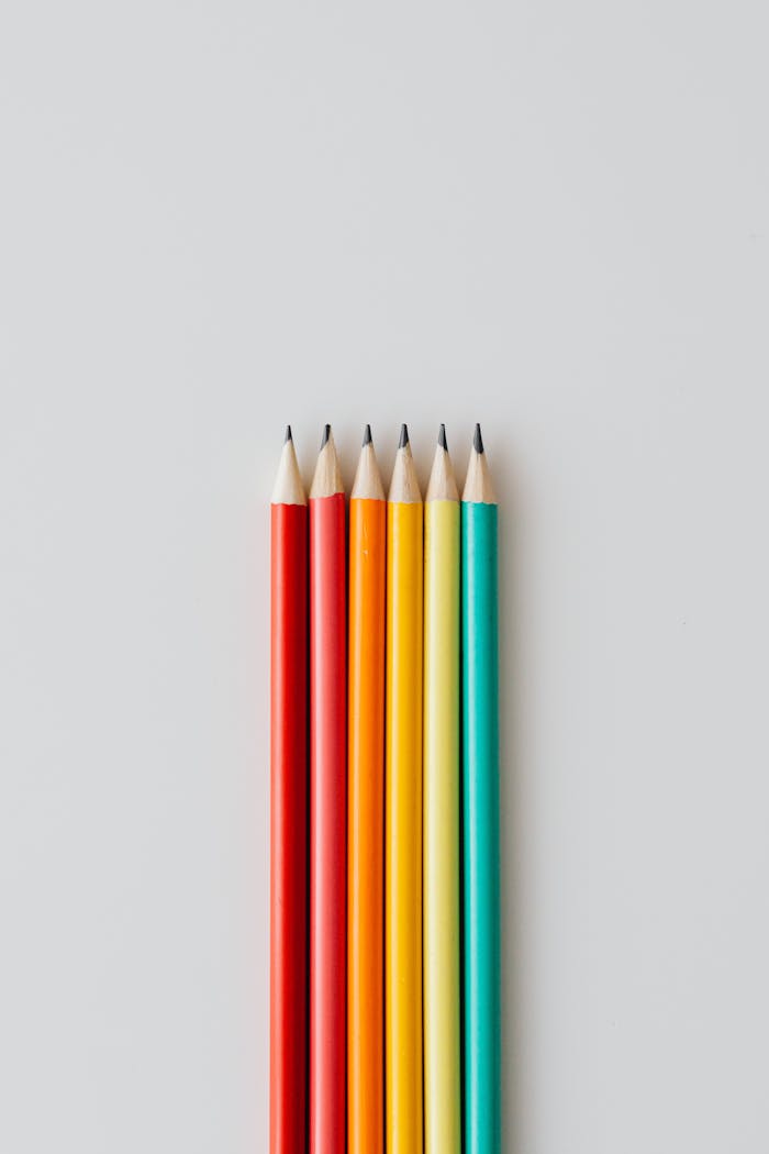 mobile-02 Six colorful pencils arranged vertically with copy space on a plain white background.
