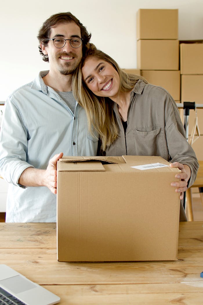 A joyful couple in Portugal starting their online business surrounded by cardboard boxes.